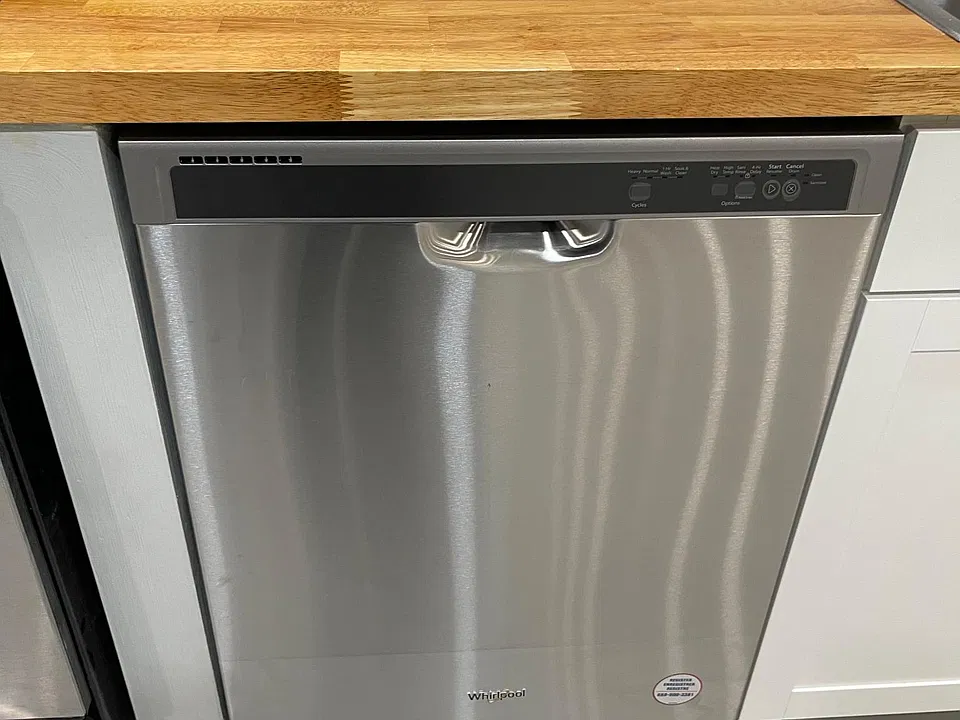 Oiled butcher block countertops and stainless steel dishwasher.