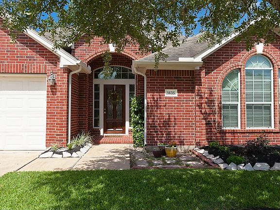 The home has beautiful landscaping and a front covered porch.