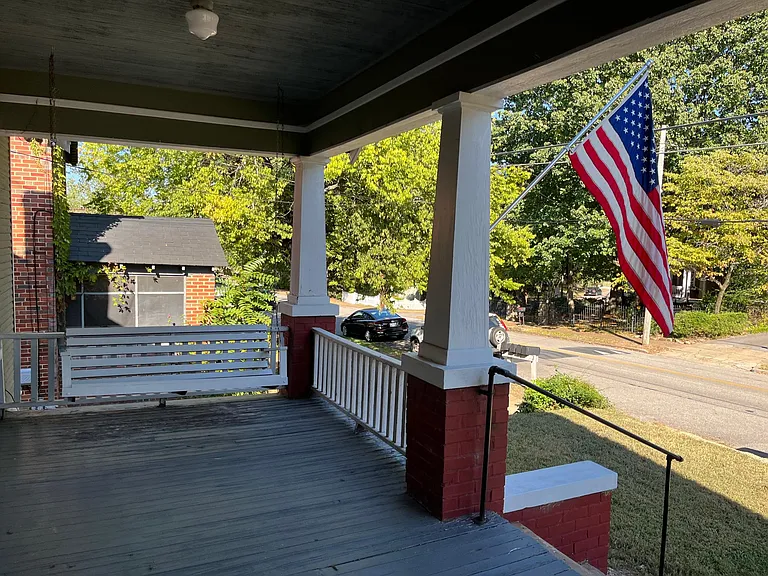 Front porch viewing street with swing