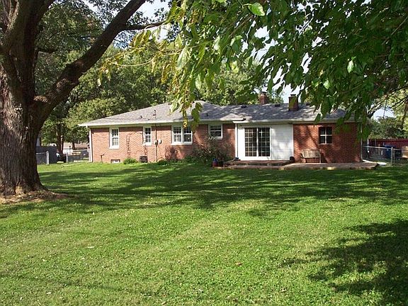Back view of the home with mature trees and a full fenced back yard!
