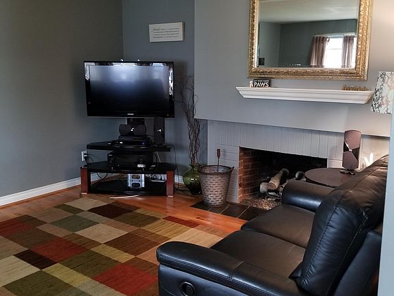 other side of living room in the front of the house, gas fireplace under mirror.