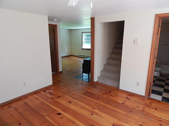 Large dining room area, kitchen and bathroom are off of this room on the right. Stairwell to second floor, with two bedrooms. There is also a bedroom to the left of this dining room area, next to the living room that you see here. Wood stove is optional.