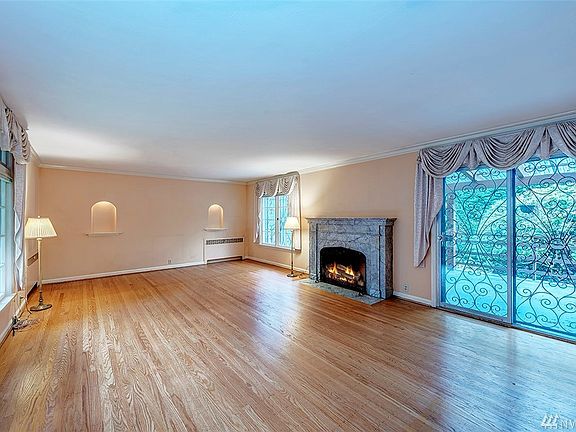Main floor living room with a marble wood burning fireplace and slider to the covered deck and back yard.