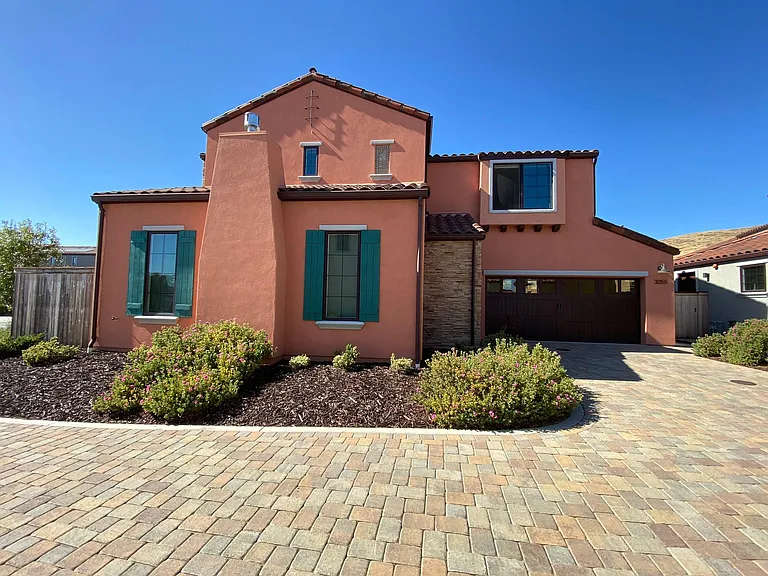 Attractive paver driveway, attached two-car garage, and welcoming front entrance.