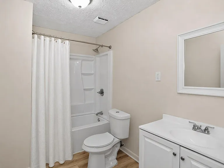 Full bathroom with tub/shower combo, vanity with storage, and framed mirror for convenient daily routines.