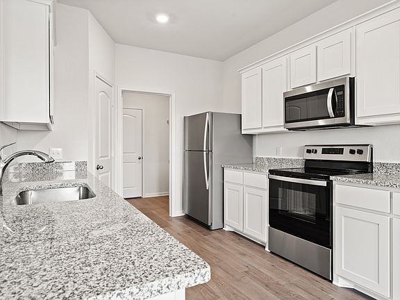 The kitchen of the Cypress has sprawling granite countertops.