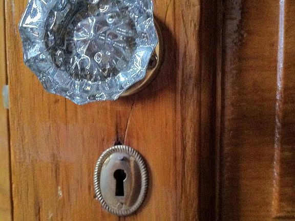 Careful attention to detail, reflected in this chestnut door with glass doorknob.