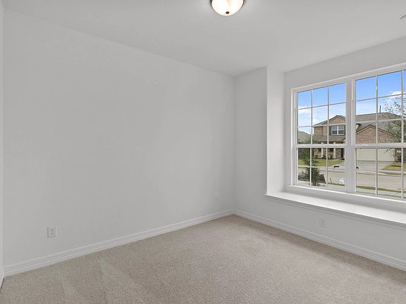 Bright and inviting main-floor bedroom with plush carpet, large windows, and ample storage.