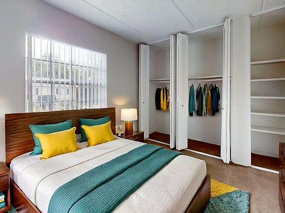 Bright and inviting bedroom with vibrant accents, featuring a cozy bed, ample closet space, and elegant decor.