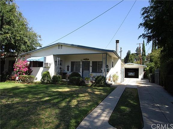 covered front porch - wrought iron driveway gate + garage