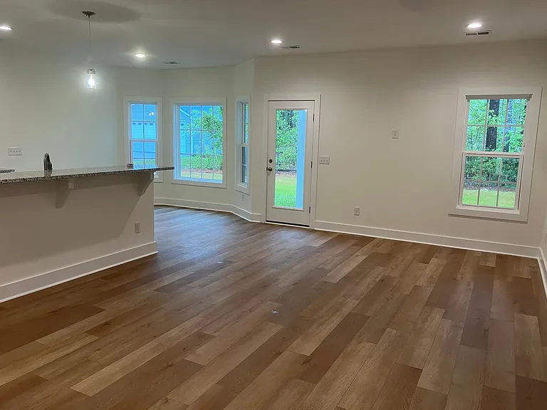 View from Living room showing serving bar and dining area. Door opens out onto 10x14 patio.