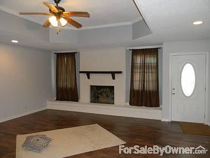 fireplace and tray ceiling
						:
						Windows beside fireplace, Sit down hearth. Trey ceiling, Dark laminate floors
