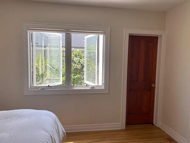 Other master bedroom walk-in closet with large windows and privacy roller shade.
