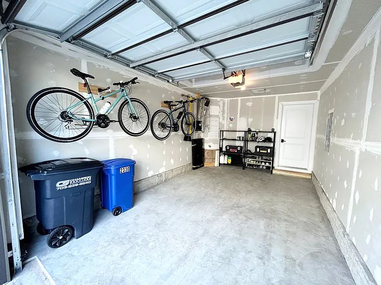 The garage features two bike mounts and a multiple-use equipment hanging rack. The garage door is smart enabled and also has keypad entry.