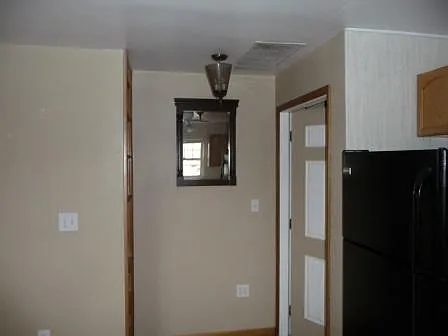 Inviting entrance, with beautiful two-tone door, expresso, wood mirror and fancy glass lighting.