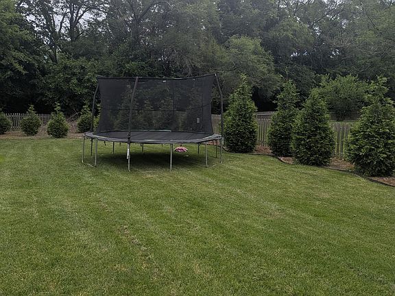 Large landscaped yard with trampoline for the kids