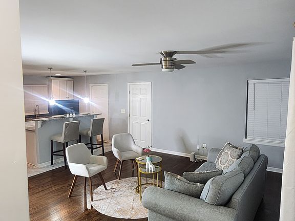 Open-concept living with hardwood floors, neutral walls, and modern lighting. Cozy seating area flows into a breakfast bar kitchen_perfect for entertaining or relaxing at home.