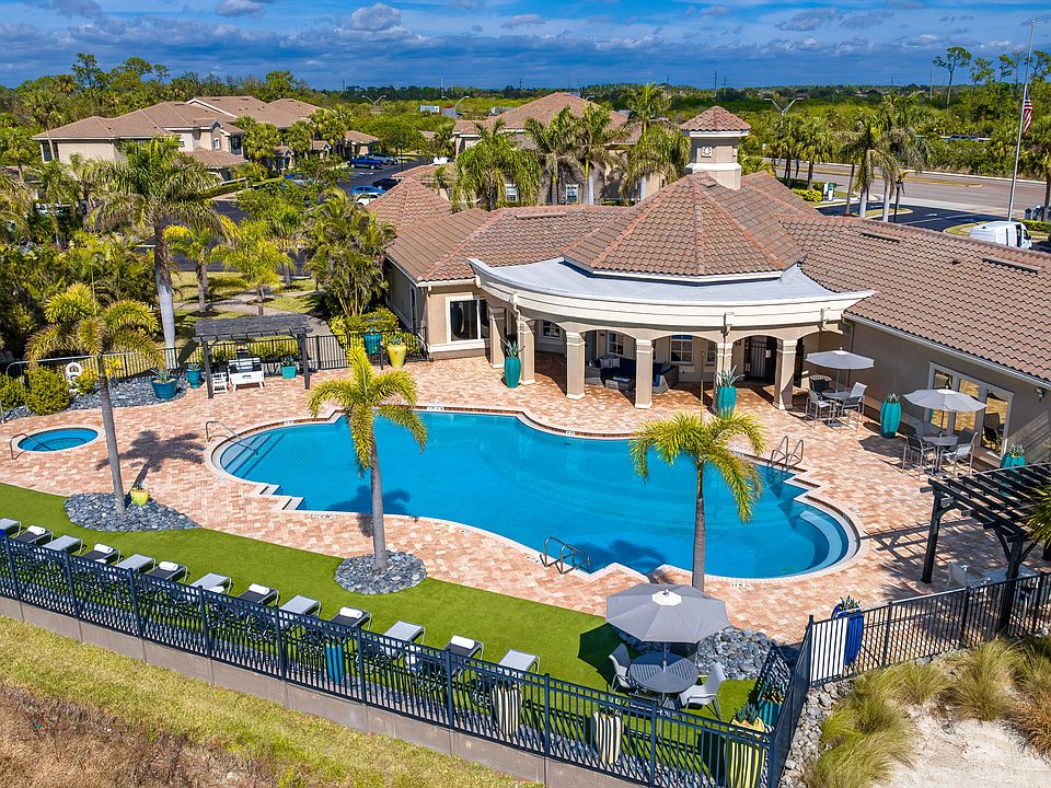 Experience true relaxation with a beautifully designed pool area featuring shaded seating and tropical landscaping.