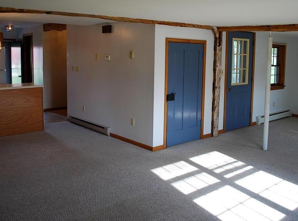 Large open living/dining floor plan with original exposed beams.