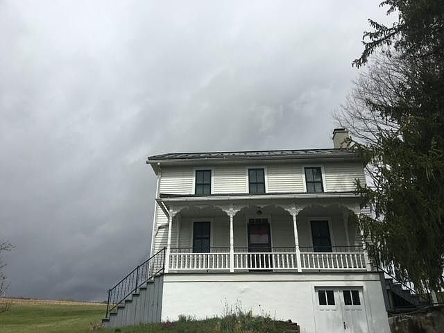 View from the street with the walk-out basement and the stairs up to the main entrance.