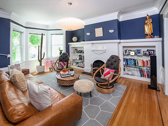 Formal living room with wood-burning fireplace and original glass pocket door leading to dining room