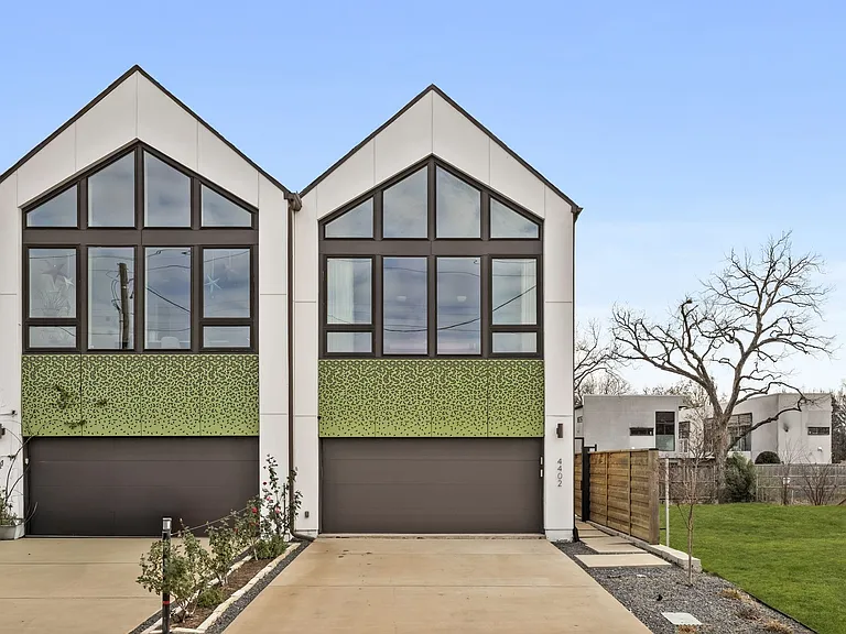 Contemporary twin residences featuring gabled rooflines and expansive window walls