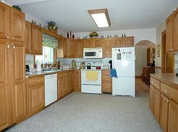 Large country kitchen has oak cabinets and all the appliances stay!
