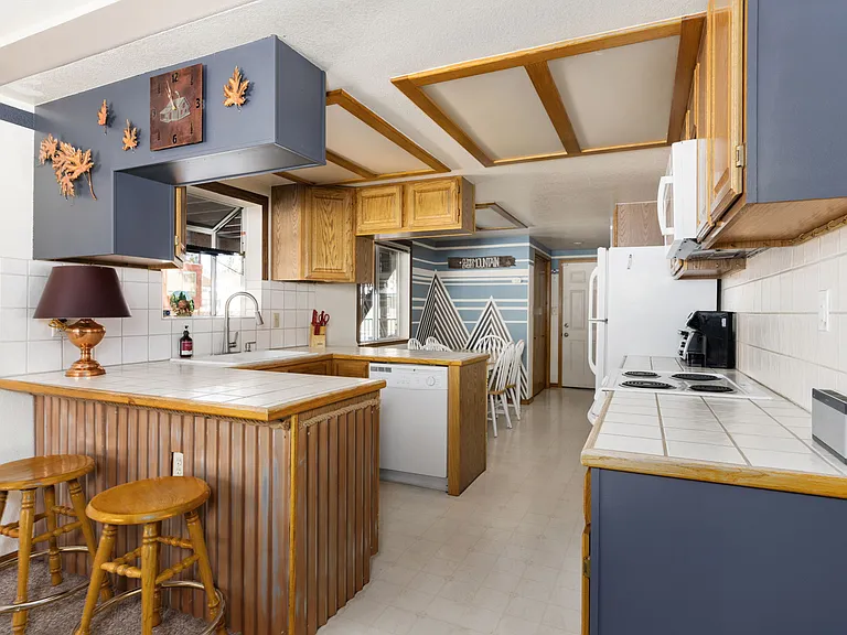 Downstairs fully stocked kitchen with island bar seating and TWO separate dining room tables perfect for large groups.