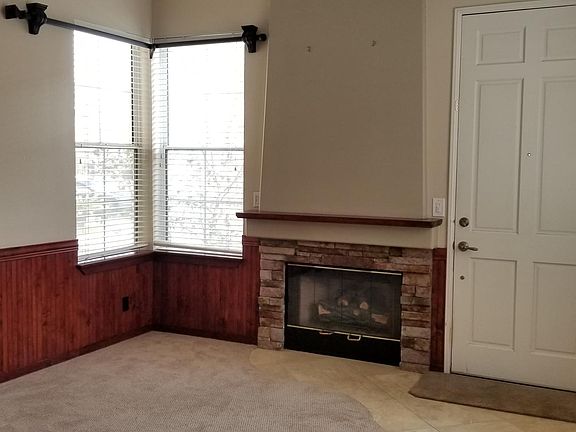 Formal Entry with custom wainscoting on the walls, Stacked Stone fireplace, Peruvian Travertine tile entry, and solid wood curtain rods over the windows