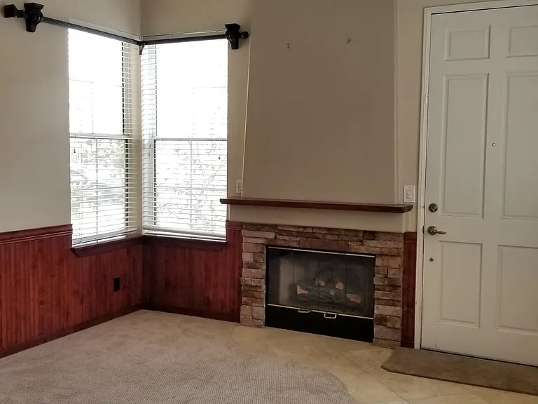 Formal Entry with custom wainscoting on the walls, Stacked Stone fireplace, Peruvian Travertine tile entry, and solid wood curtain rods over the windows