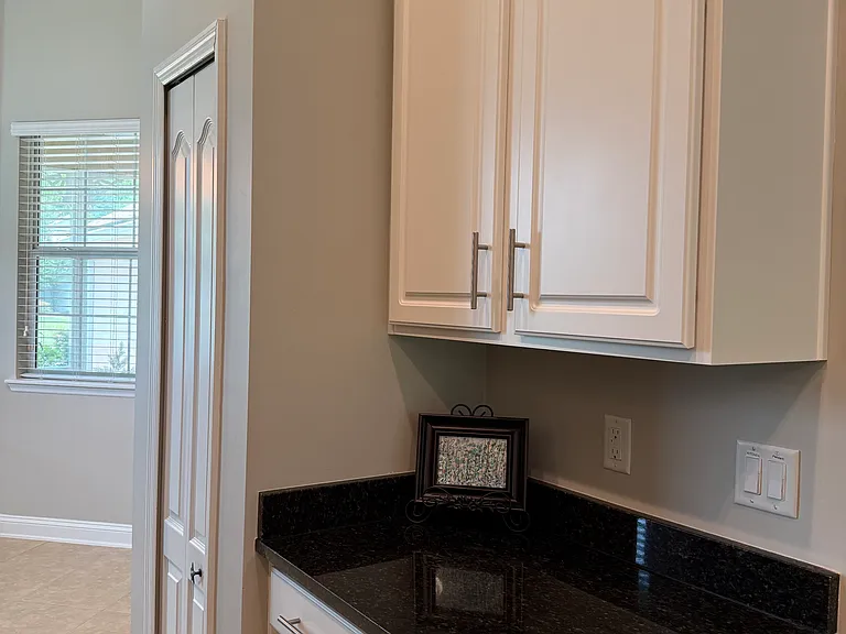 Cabinetry across from refrigerator. Coffee bar