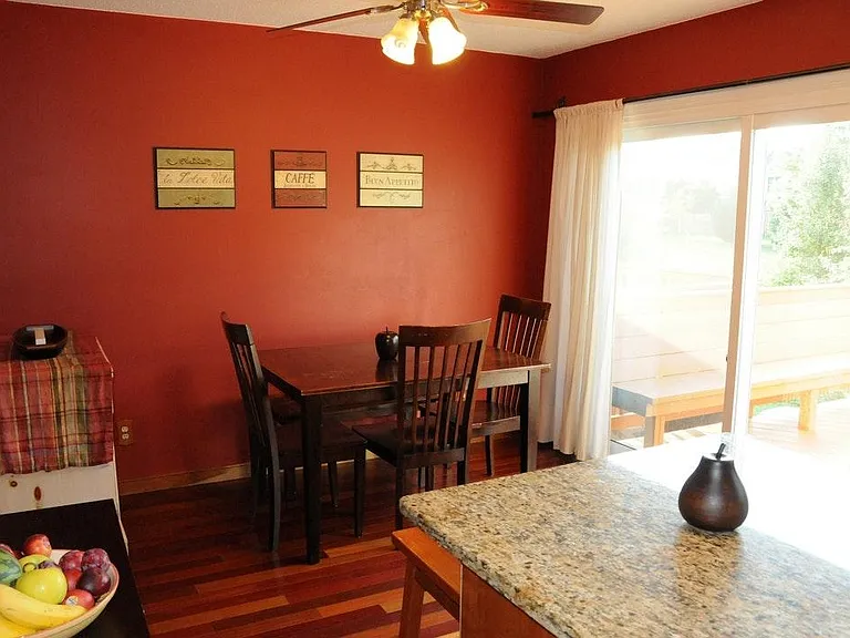 Dining room with sliding door leading out to mainfloor balcony overlooking park behind the house.