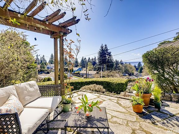 A welcoming patio in front, great for entertaining and enjoying the lovely terraced landscaping.