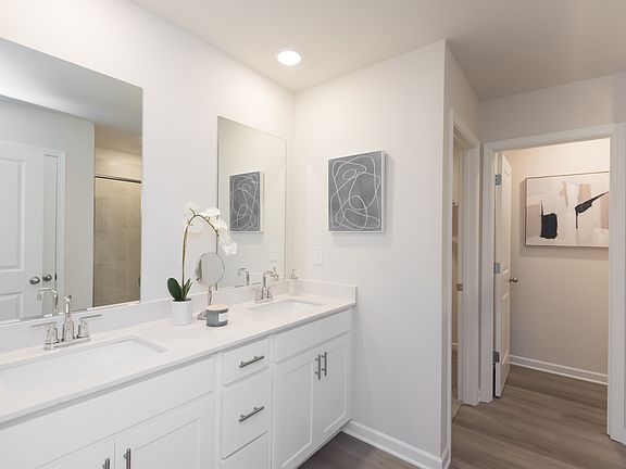 The ensuite bathroom features dual-vanity sinks and a walk-in closet.