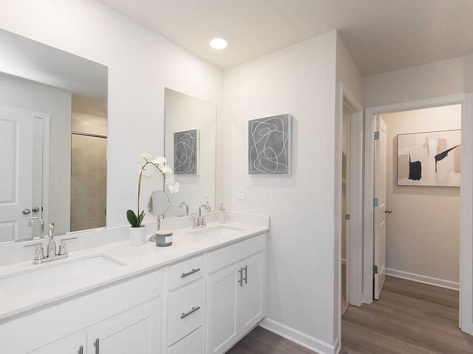 The ensuite bathroom features dual-vanity sinks and a walk-in closet.