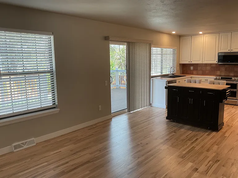 View from family room to kitchen w/ exit to outdoor deck