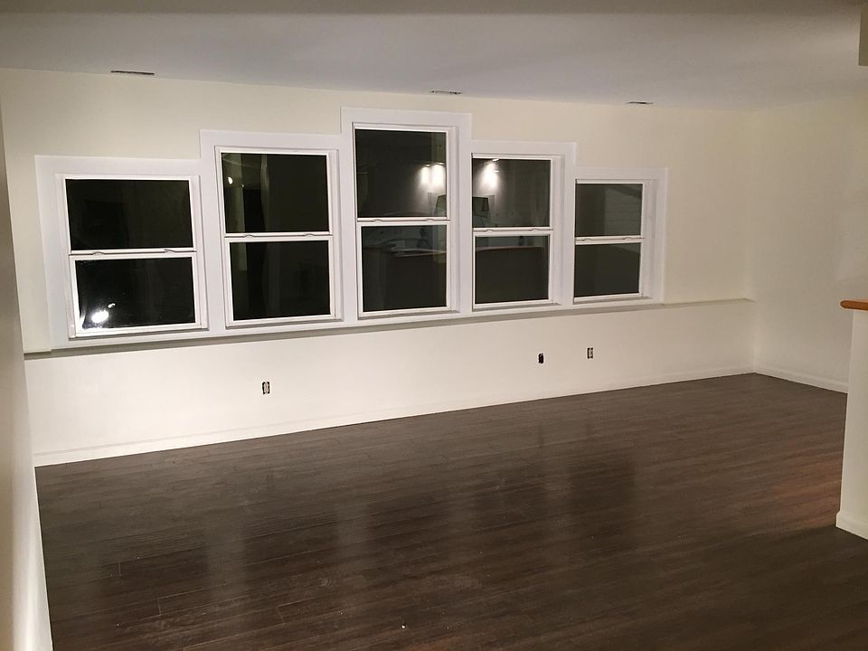 Living room.  Windows look out onto lawn and woods.