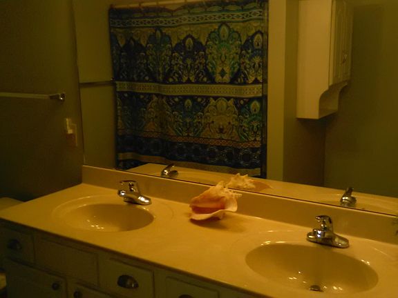 The shower stall is behind the curtain. There are sliding glass doors in addition.