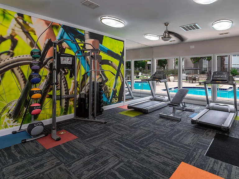 Our fully equipped fitness center features treadmills, free weights, and sunny views of the resort-style pool.