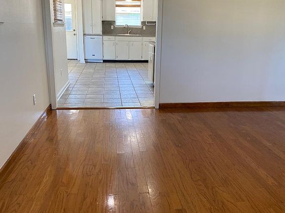 Living Room 12'X18' with Wood Floors, Ceiling Fan Light and Window Bilnds opens to Wet Bar, Kitchen and Family Room with ceramic tile floors.