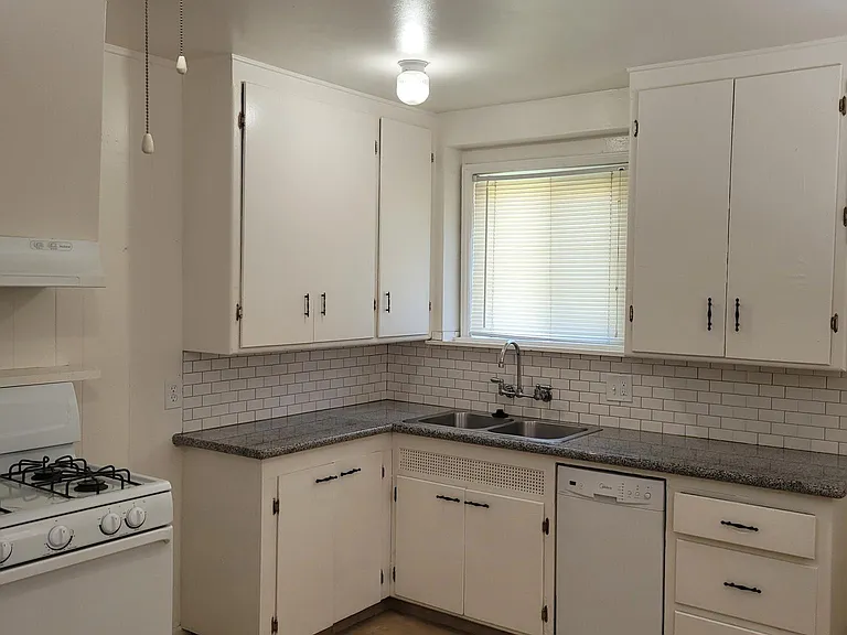 Kitchen with granite countertops and gas stove.