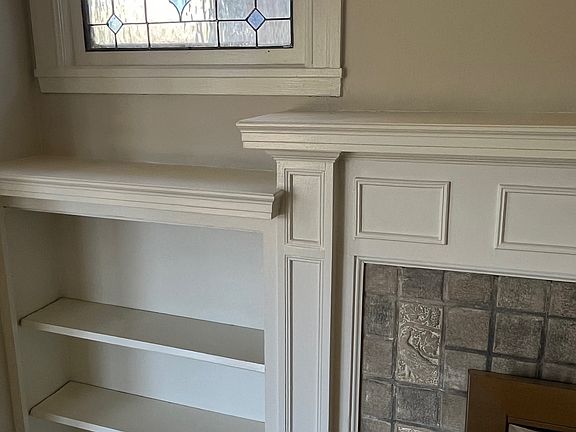living room built ins, stained glass window and original fireplace tiles