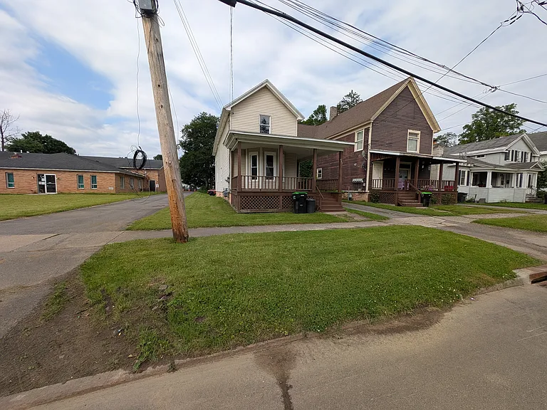 View from street. Driveway between 2 houses leads to plenty of parking in rear