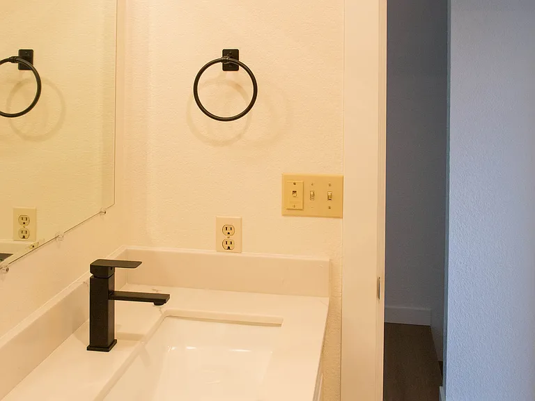 Updated bathroom with modern vanity, black fixtures, and clean finishes. Bright and refreshed space with freshly updated details.