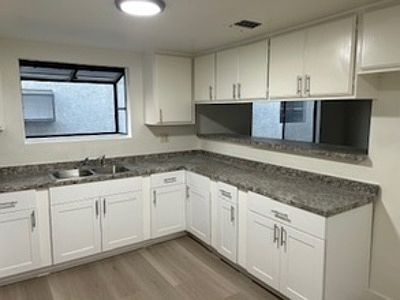 Kitchen remodeled with new cabinets, greenhouse window, new countertops, and pass through countertop. Kitchen connects to dining area.