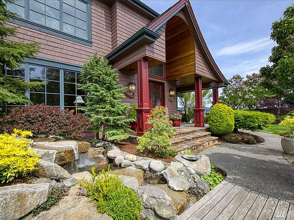 The waterfall flows under the bridge into the pond surrounded  by beautiful plantings and trees. All the different textures and colors of foliage will take your breath away.