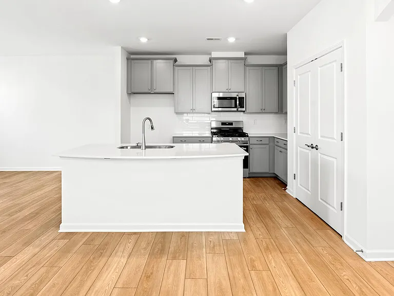 Kitchen Area View- Quartz Countertops, Tile Backsplash, With All New Appliances and Island Area Featuring Overhang for Breakfast Area/ Barstools.