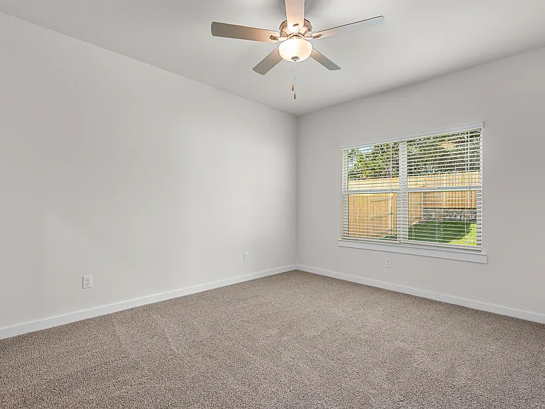 The spacious master bedroom has a window that lets in great, natural light and backyard views.