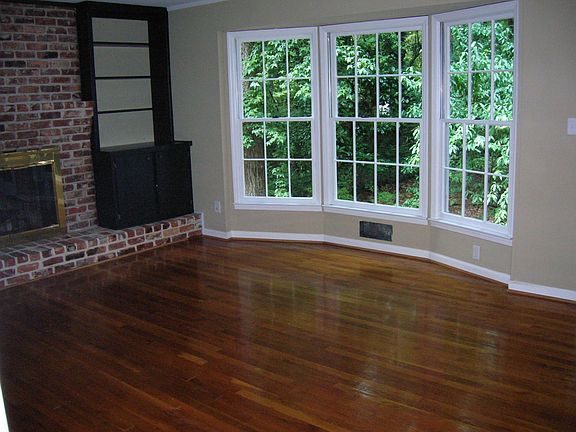Family room w/ bay window and brick fireplace encased by bookshelves
