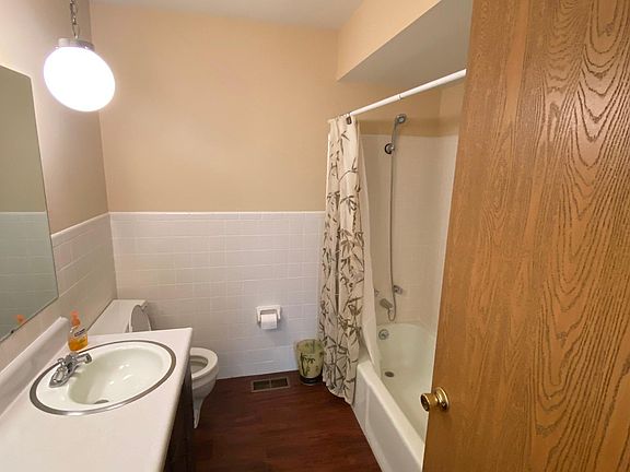 Hall bathroom with tub and shower unit. Just installed new flooring!